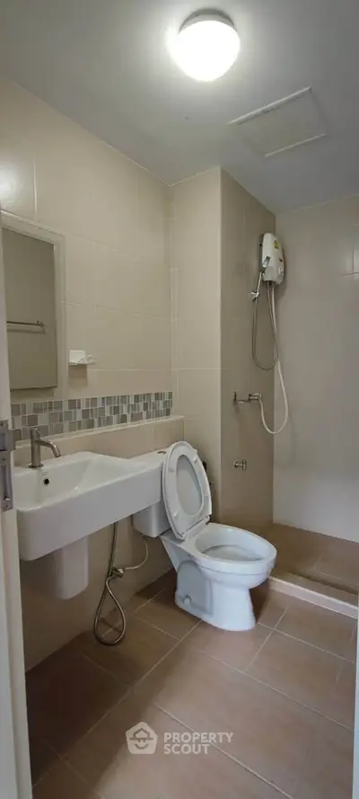 Modern bathroom with shower and toilet in a sleek real estate property.