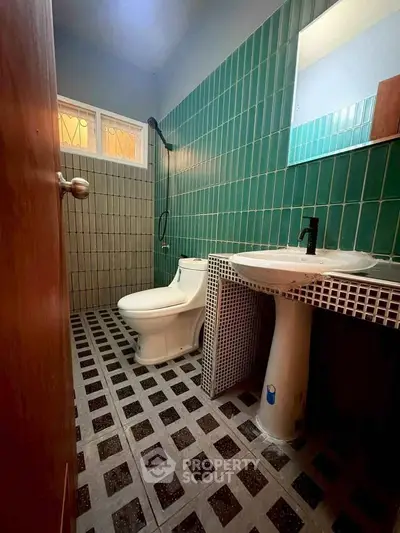 Charming bathroom with vintage green tiles and modern fixtures, perfect for a cozy home.
