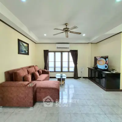 Spacious living room with cozy sofa and modern entertainment setup.