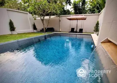 Luxurious private pool with waterfall feature in serene garden setting