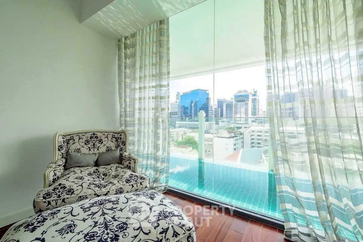 Luxurious living room with elegant armchair and stunning city view from large window.