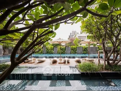 Luxurious outdoor pool area with lush greenery and stylish sun loungers, perfect for relaxation and leisure.
