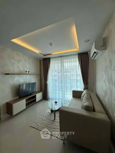 Modern living room with stylish ceiling lights, large window, and cozy furniture in a contemporary apartment.