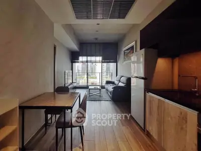 Modern living room with open kitchen and city view, featuring sleek furniture and wooden flooring.
