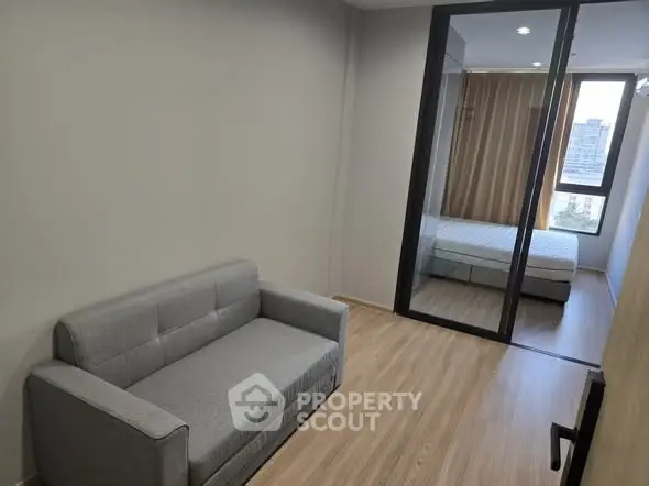 Modern apartment with cozy living area and bedroom, featuring sleek design and natural light.