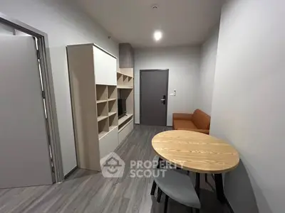 Modern living room with sleek furniture and dining area in contemporary apartment.