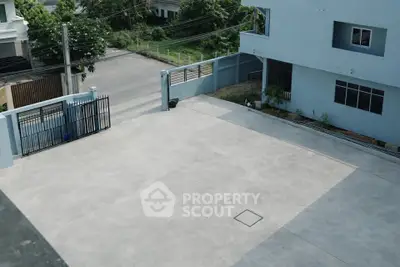 Spacious residential driveway with secure gated entrance and modern exterior design.