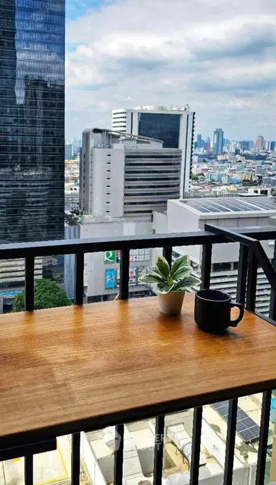 Stunning city view from a modern balcony with coffee and plant decor.