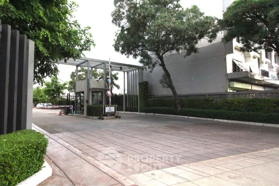 Modern gated entrance with lush greenery and sleek design