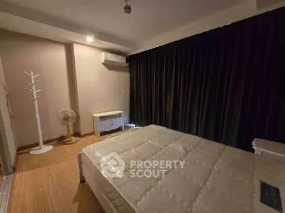 Cozy bedroom with modern furnishings and dark curtains, perfect for restful nights.