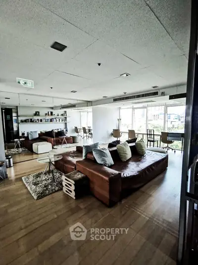 Spacious modern living room with stylish furniture and large windows offering natural light.