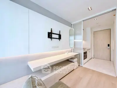Modern minimalist living room with sleek built-in furniture and open kitchen layout.
