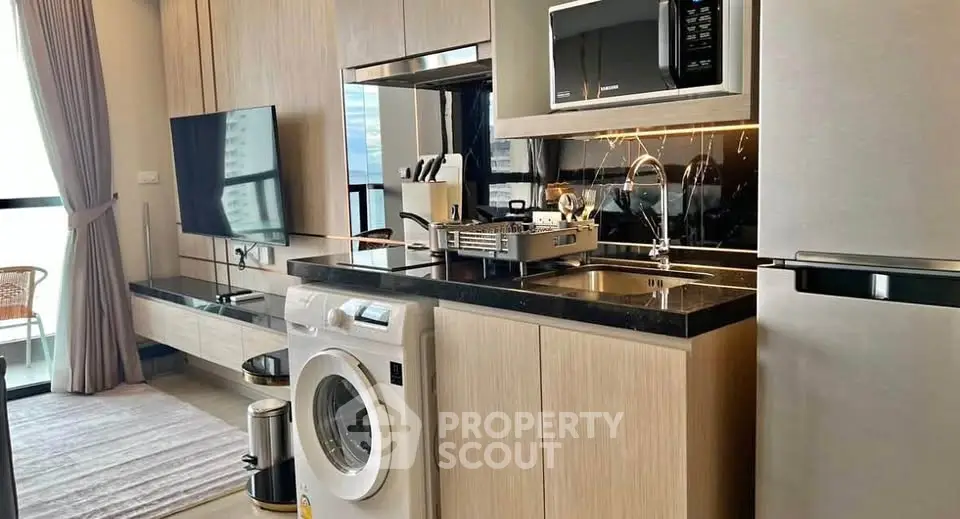 Modern kitchen with sleek appliances and washing machine in stylish apartment