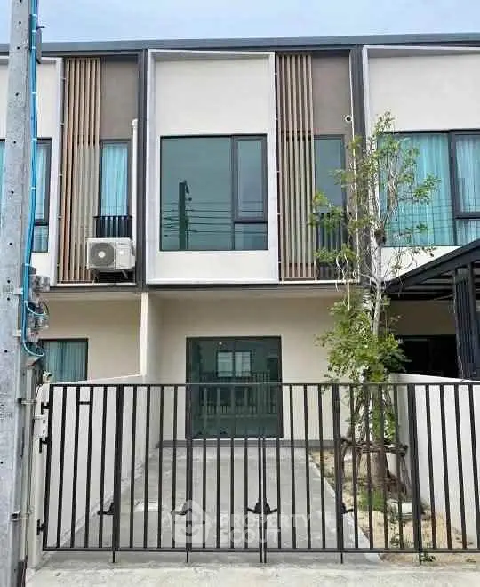 Modern townhouse exterior with sleek design and gated entrance