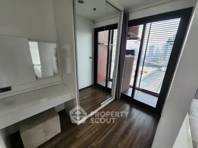 Modern bedroom with mirrored closet and city view balcony