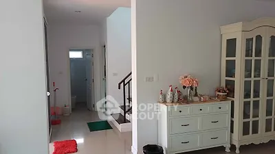 Charming interior with elegant staircase and stylish storage cabinet in a cozy home setting.