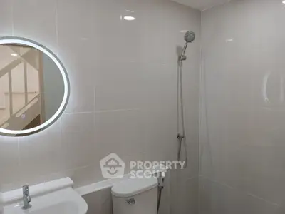 Modern bathroom with sleek shower and round mirror