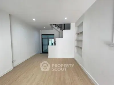 Spacious modern living room with wooden flooring and built-in shelves
