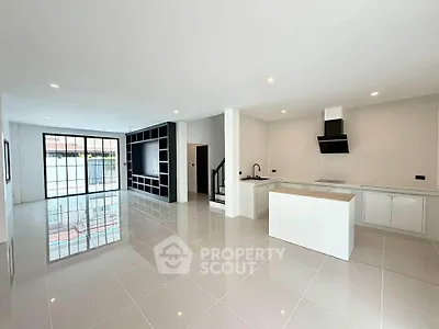 Spacious modern open-plan living room with sleek kitchen and large windows