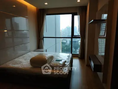 Modern bedroom with large window offering stunning city view in high-rise apartment