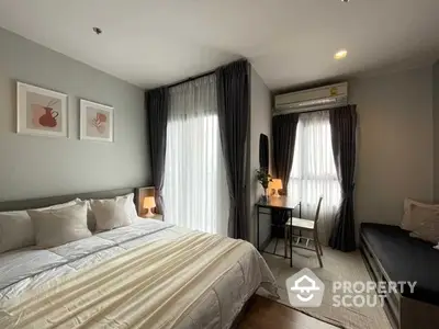 Elegant bedroom with large bed, stylish decor, ample natural light, and cozy sitting area, perfect for modern living.