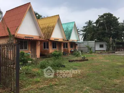 Charming row of colorful A-frame houses with lush greenery and spacious yard.