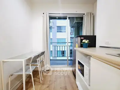 Modern compact kitchen with balcony view in urban apartment