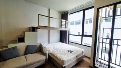 Modern loft bedroom with large windows and cozy sofa in stylish apartment