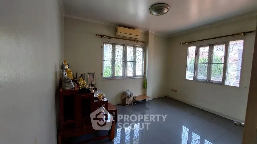 Spacious room with tiled flooring and large windows, ideal for versatile use.