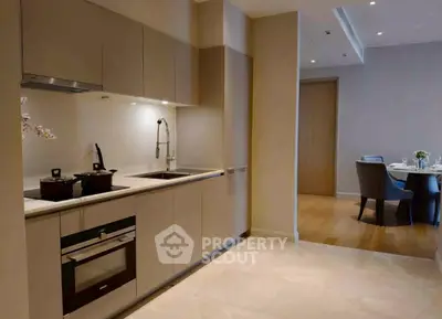 Modern kitchen with sleek cabinetry and dining area in luxury apartment