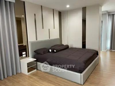 Modern bedroom with sleek design and stylish decor, featuring a comfortable bed and elegant curtains.