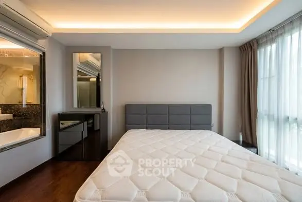 Modern bedroom with large window and stylish lighting, featuring a comfortable bed and sleek decor.