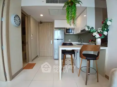 Modern kitchen with sleek design, featuring a breakfast bar, washing machine, and stylish decor.