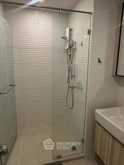 Modern bathroom with glass shower enclosure and sleek fixtures.
