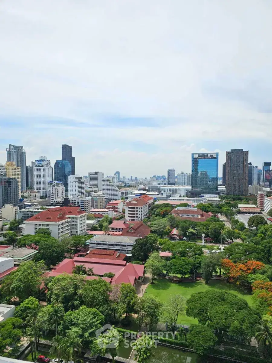 Stunning cityscape view from a high-rise building showcasing lush greenery and urban skyline.