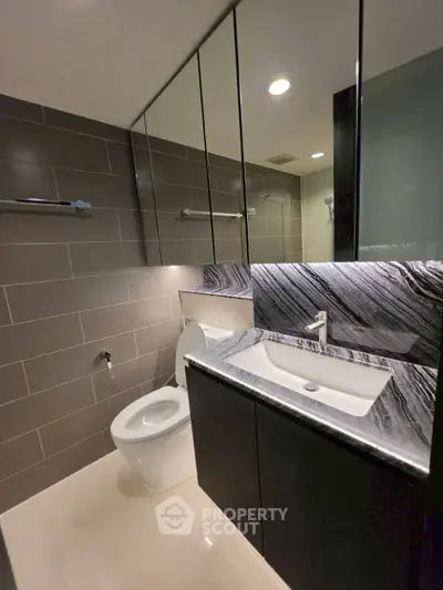 Modern bathroom with sleek design, featuring a stylish sink and toilet, perfect for contemporary living.