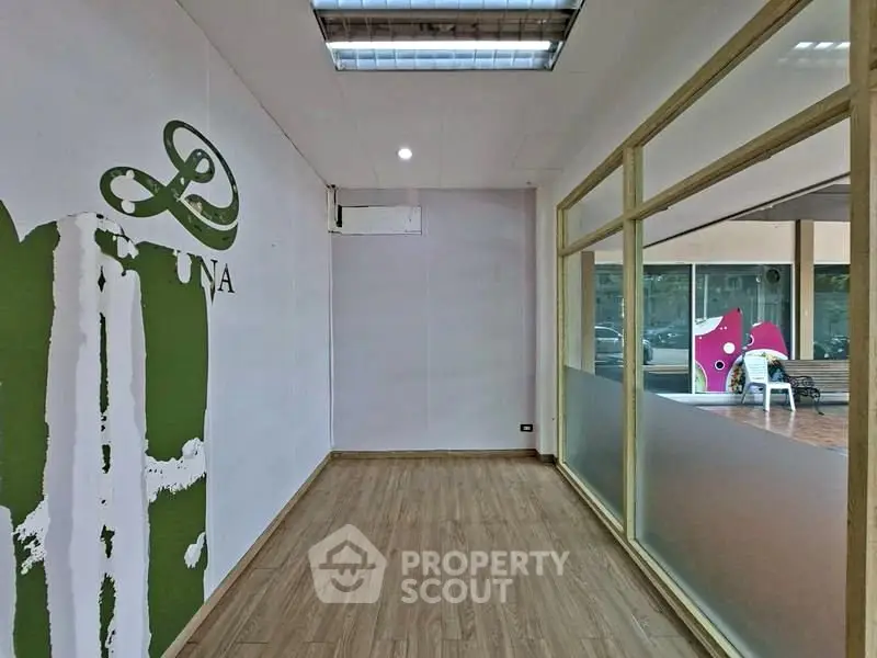 Spacious commercial space with large windows and modern flooring, ideal for retail or office use.