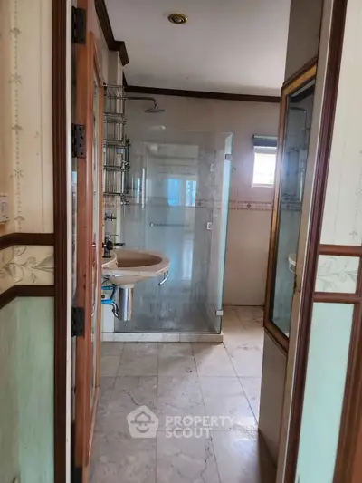 Spacious bathroom with glass shower and elegant tile flooring