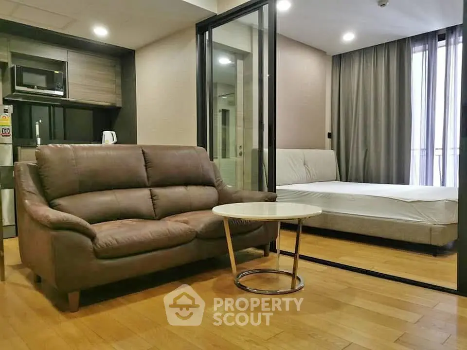 Modern studio apartment with open layout, featuring a cozy living area and sleek kitchen.