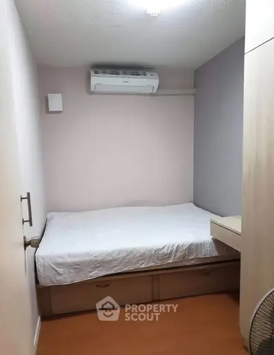 Cozy compact bedroom with built-in storage and air conditioning, perfect for efficient living.