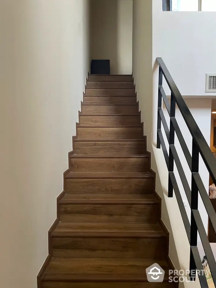 Modern wooden staircase with sleek railing in contemporary home interior