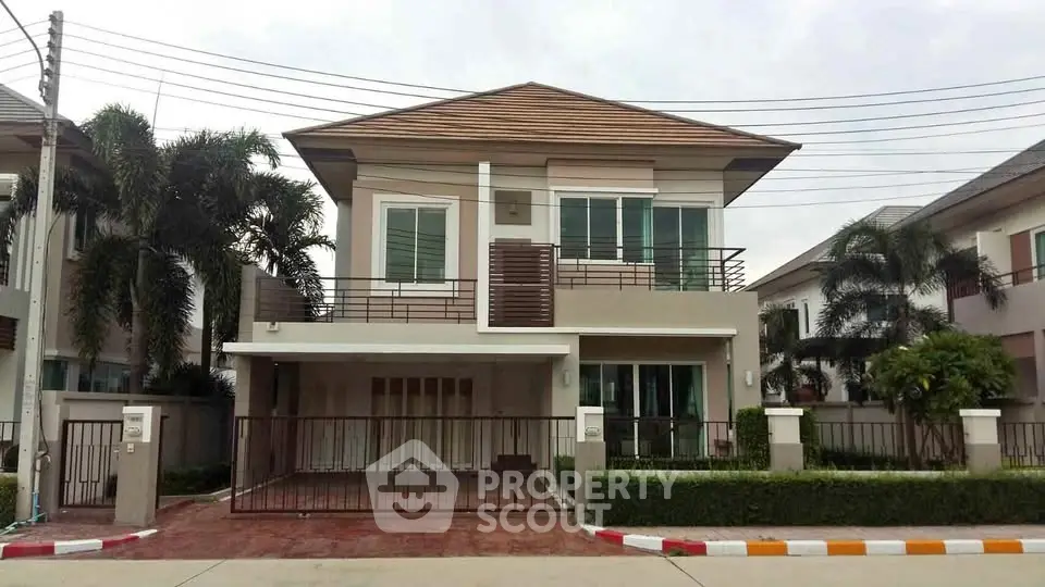 Modern two-story house with balcony and landscaped front yard in a suburban neighborhood.
