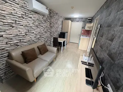 Modern living room with stylish stone accent wall and compact kitchen area.