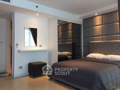 Modern bedroom with stylish decor and mirrored wardrobe in a cozy apartment.
