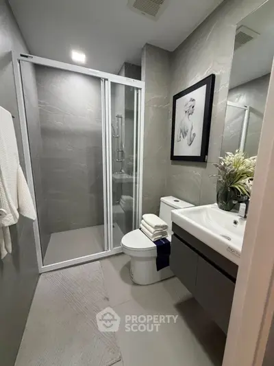 Modern bathroom with sleek shower and elegant decor in luxury apartment.