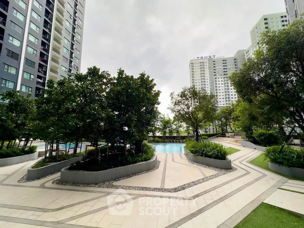 Modern residential complex with lush garden and pool view