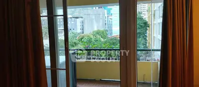 Spacious balcony with city view and lush greenery, perfect for relaxation and urban living.