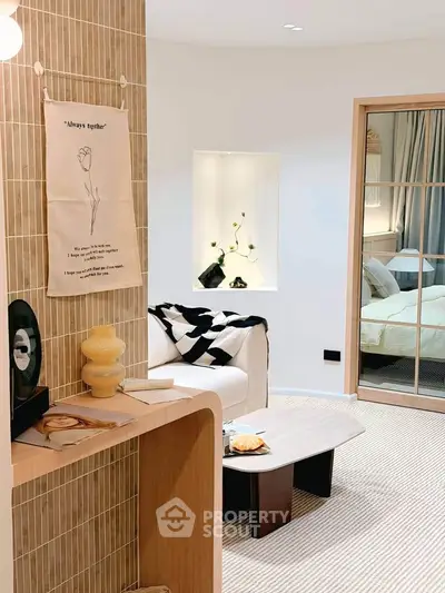 Stylish modern living room with cozy decor and view into a chic bedroom
