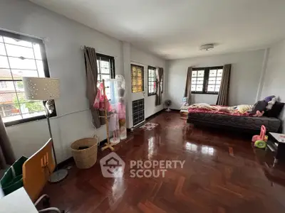 Spacious bedroom with wooden flooring and ample natural light, ideal for a cozy family home.