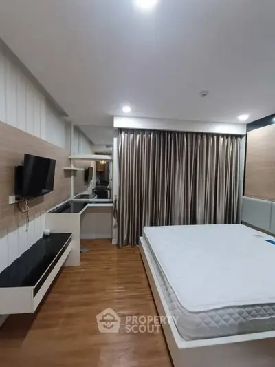 Modern bedroom with sleek design, featuring a mounted TV, stylish curtains, and a comfortable bed.